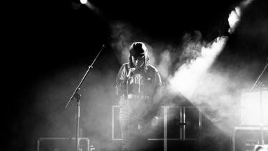 black and white photo of young person on stage performing